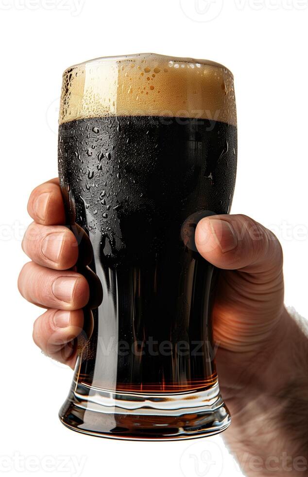 Close up of a man's hand holding a glass with dark beer isolated on a white background photo