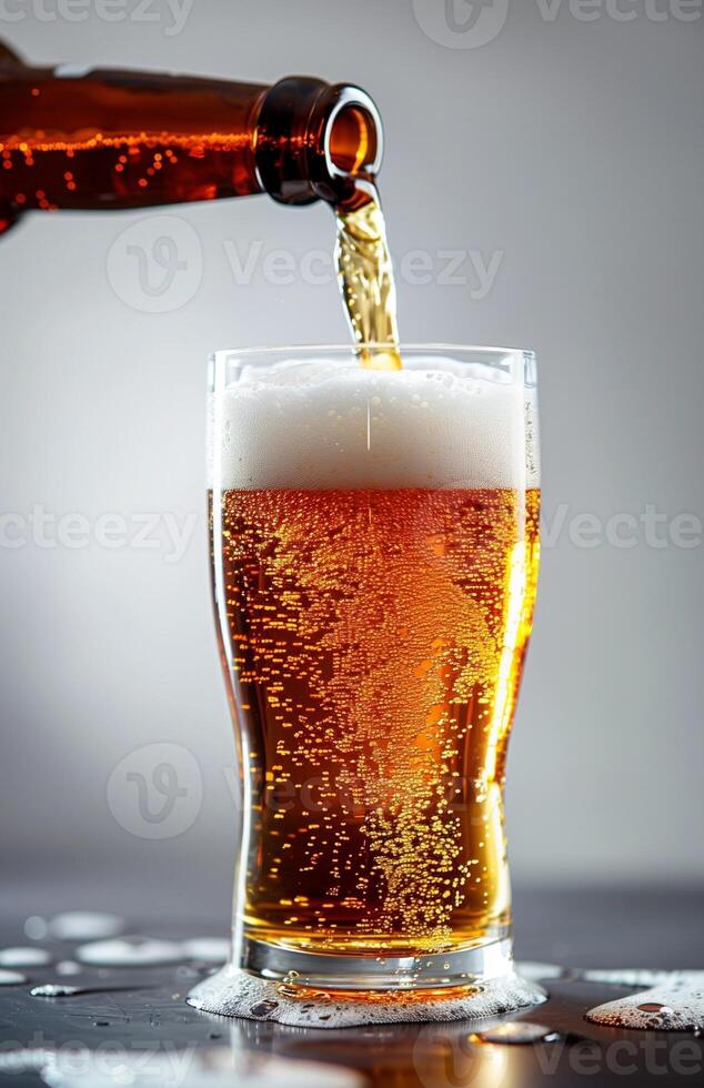 Pouring a glass of golden beer, creating a frothy head, ready to be enjoyed photo