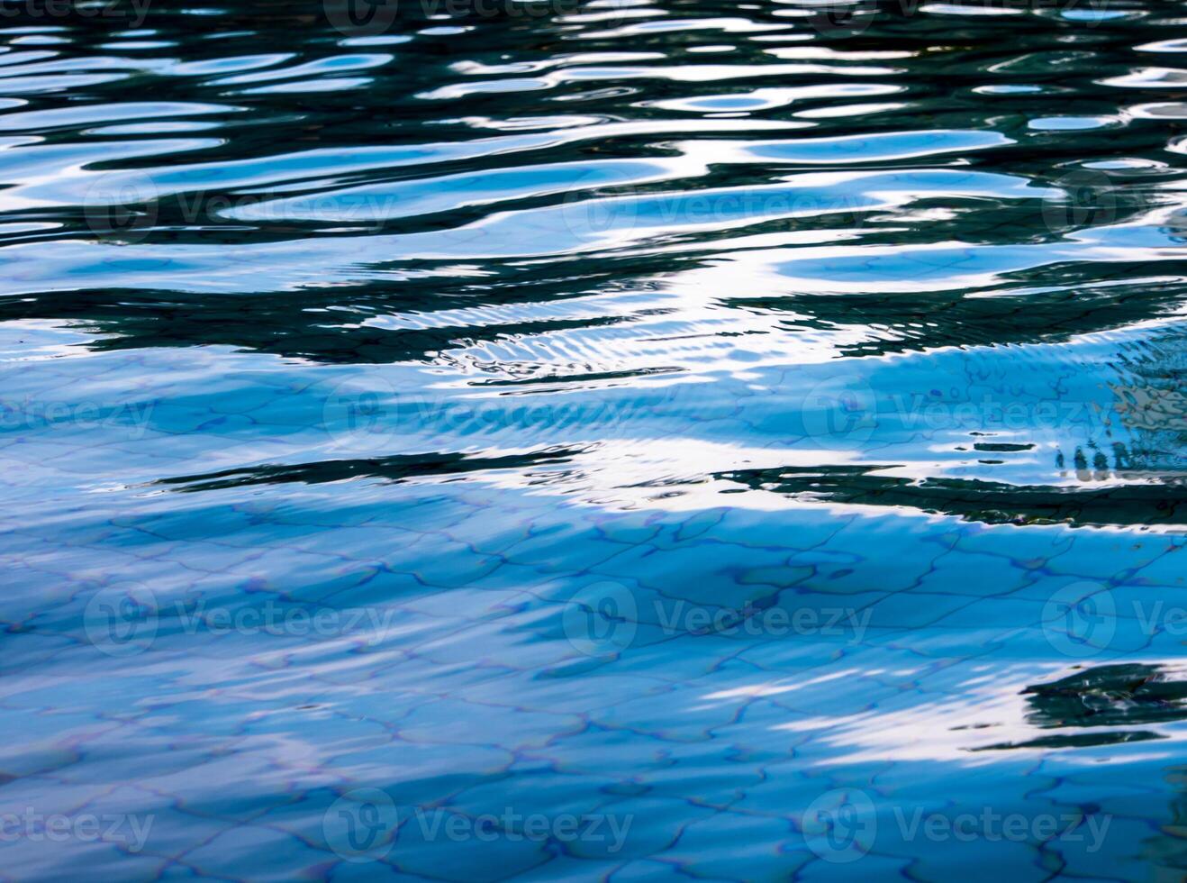 Reflection of sky on the moving water surface in the pool photo