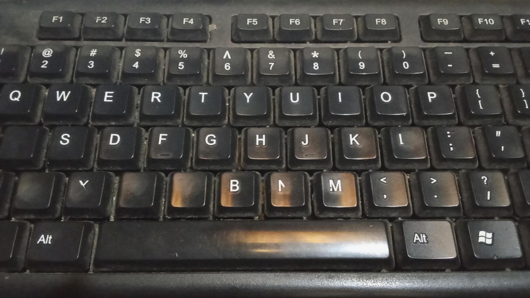 Alphabet letters on a working keyboard shot from under a lamp photo
