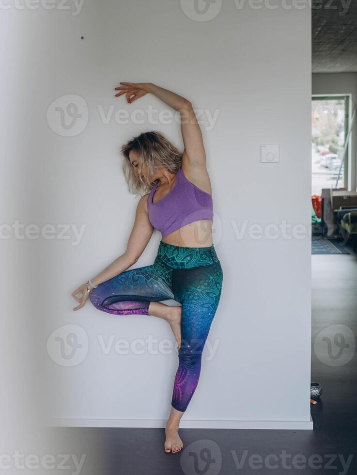 Attractive young woman practing yoga stretching yoga at home. photo