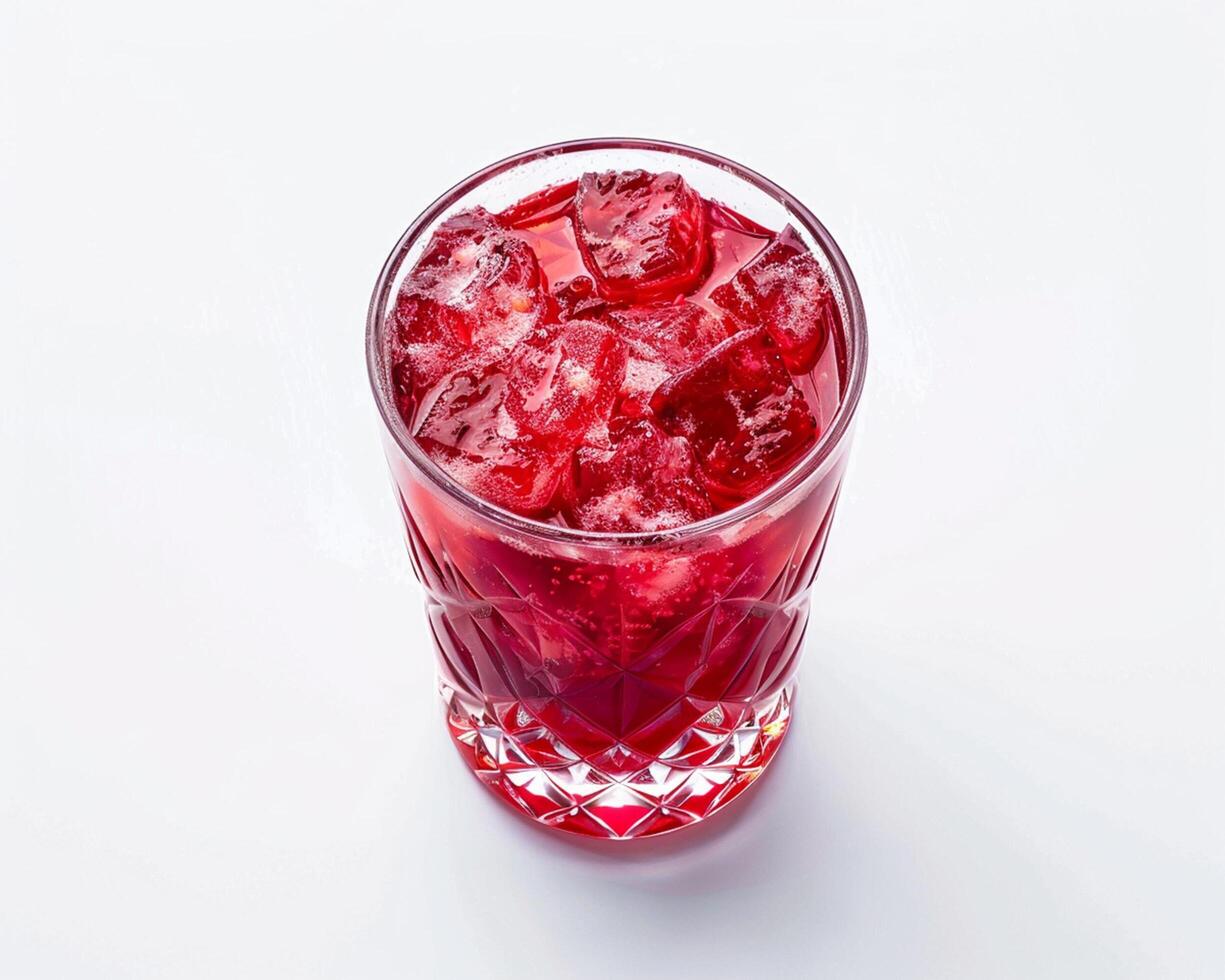 a glass of red drink with ice cubes photo