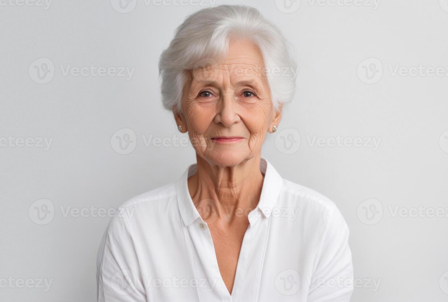 Elderly woman portrait looking to camera on gray background photo