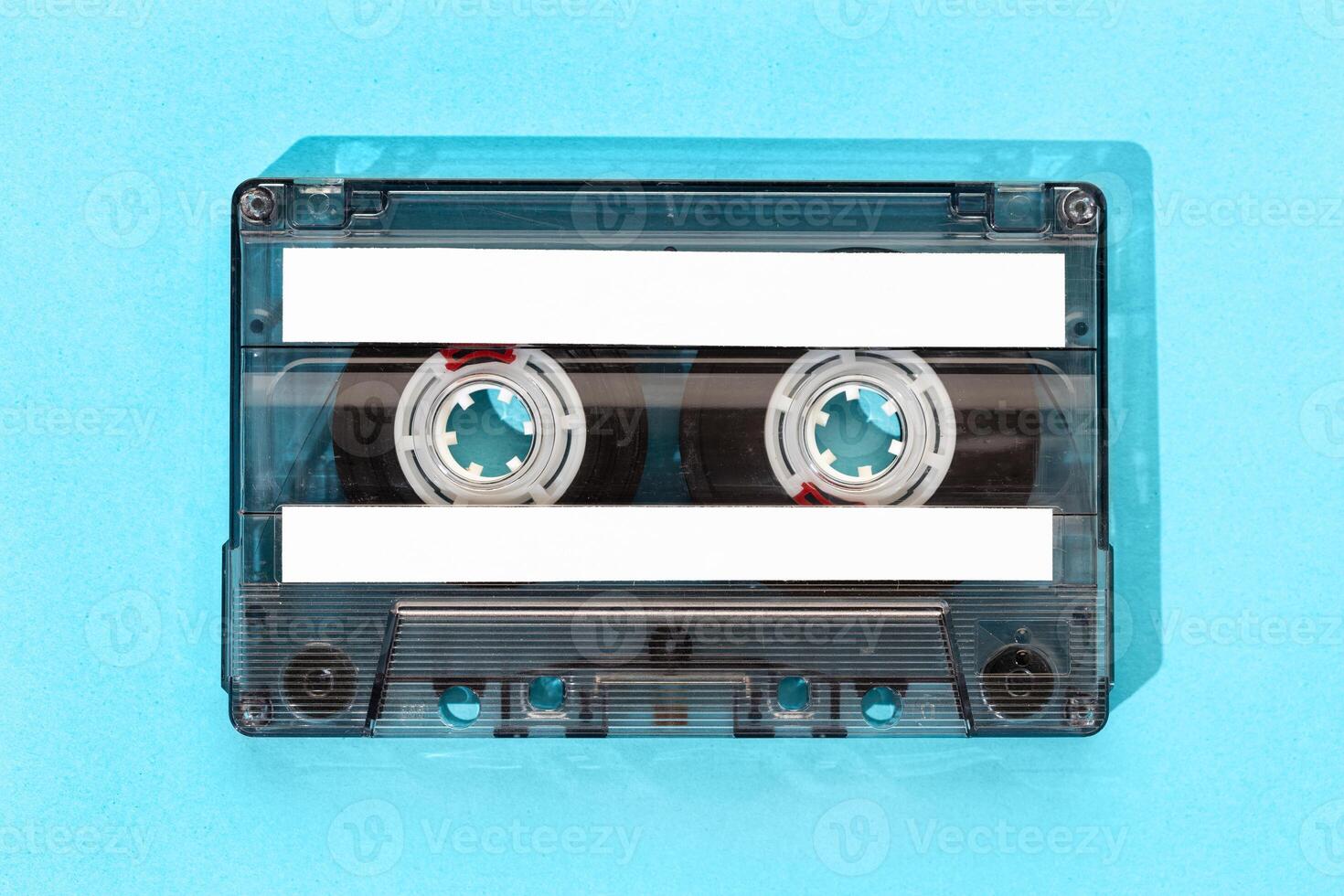 Old tape cassette with blank labels isolated on blue background, Template mock up photo