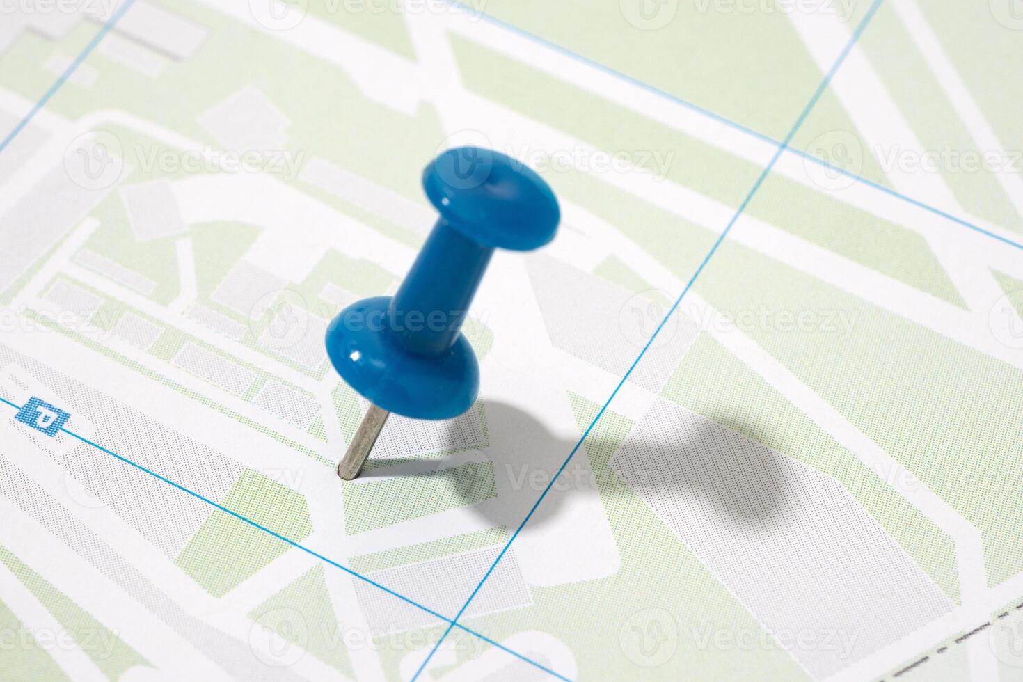 Thumbtack on a paper city map. Map location concept photo