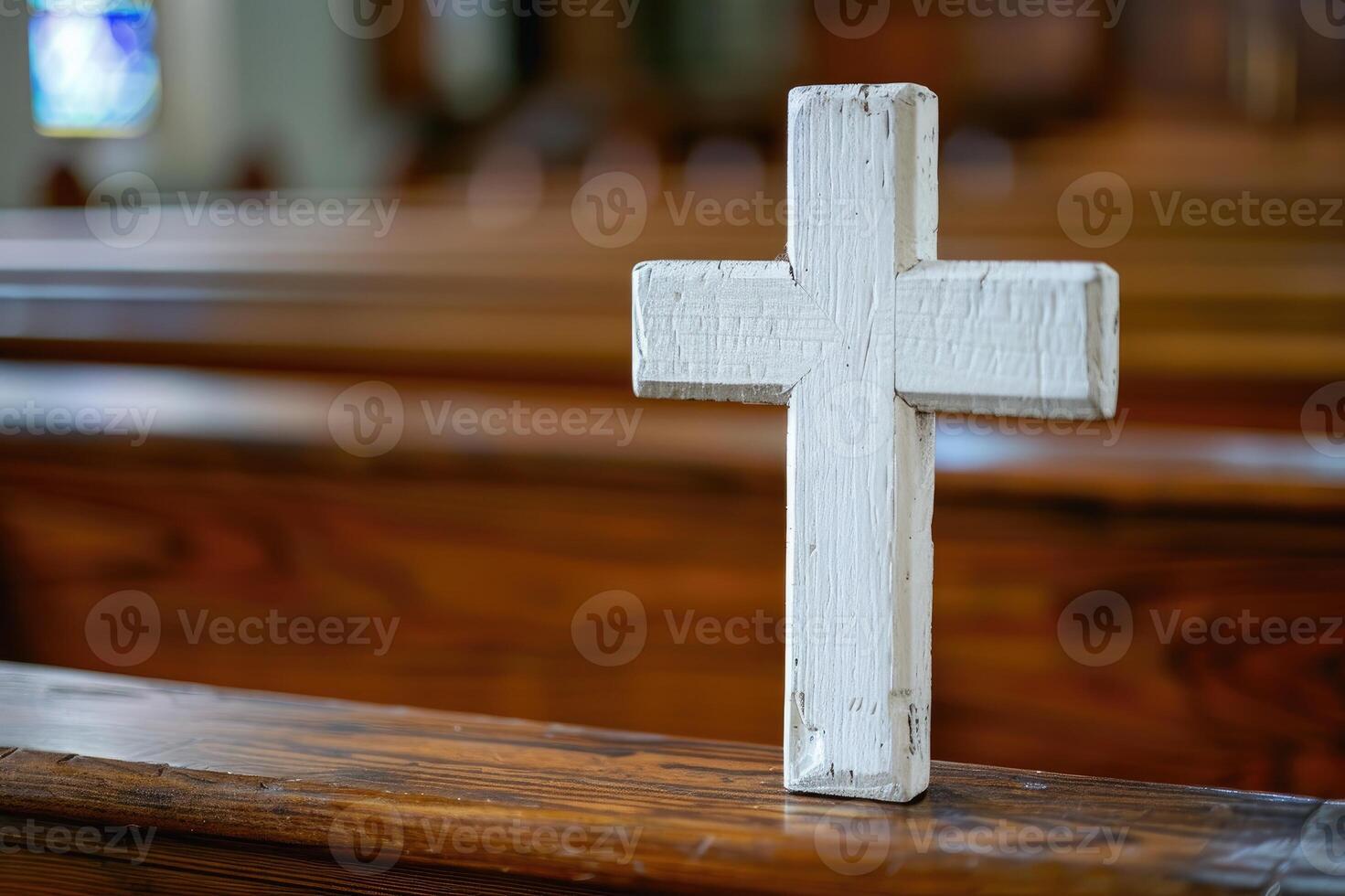 Wooden cross on a pew inside a church with warm lighting and soft focus photo