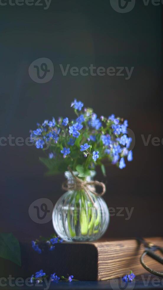 bouquet of blue forget-me-nots in a glass vase. congratulation, beautiful card for birthday, mother's day and wedding photo