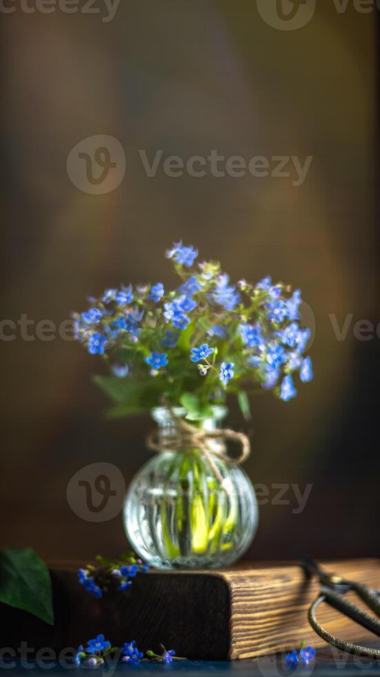 bouquet of blue forget-me-nots in a glass vase. congratulation, beautiful card for birthday, mother's day and wedding photo