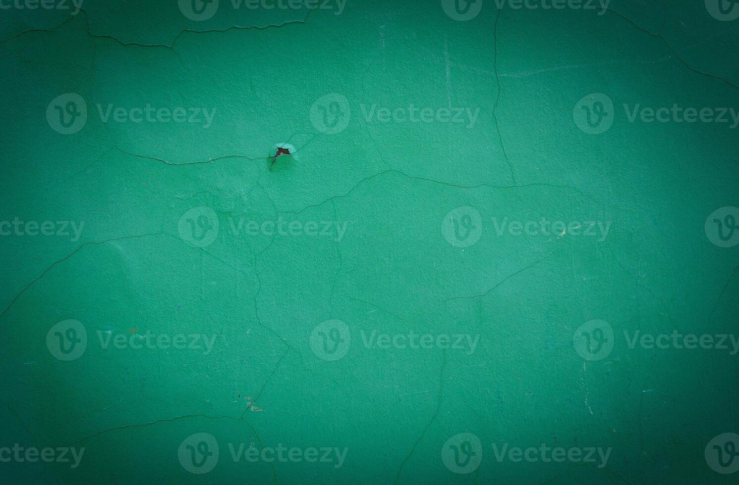 blank green texture surface background with dark corners. green grainy cement wall background with space for text. photo