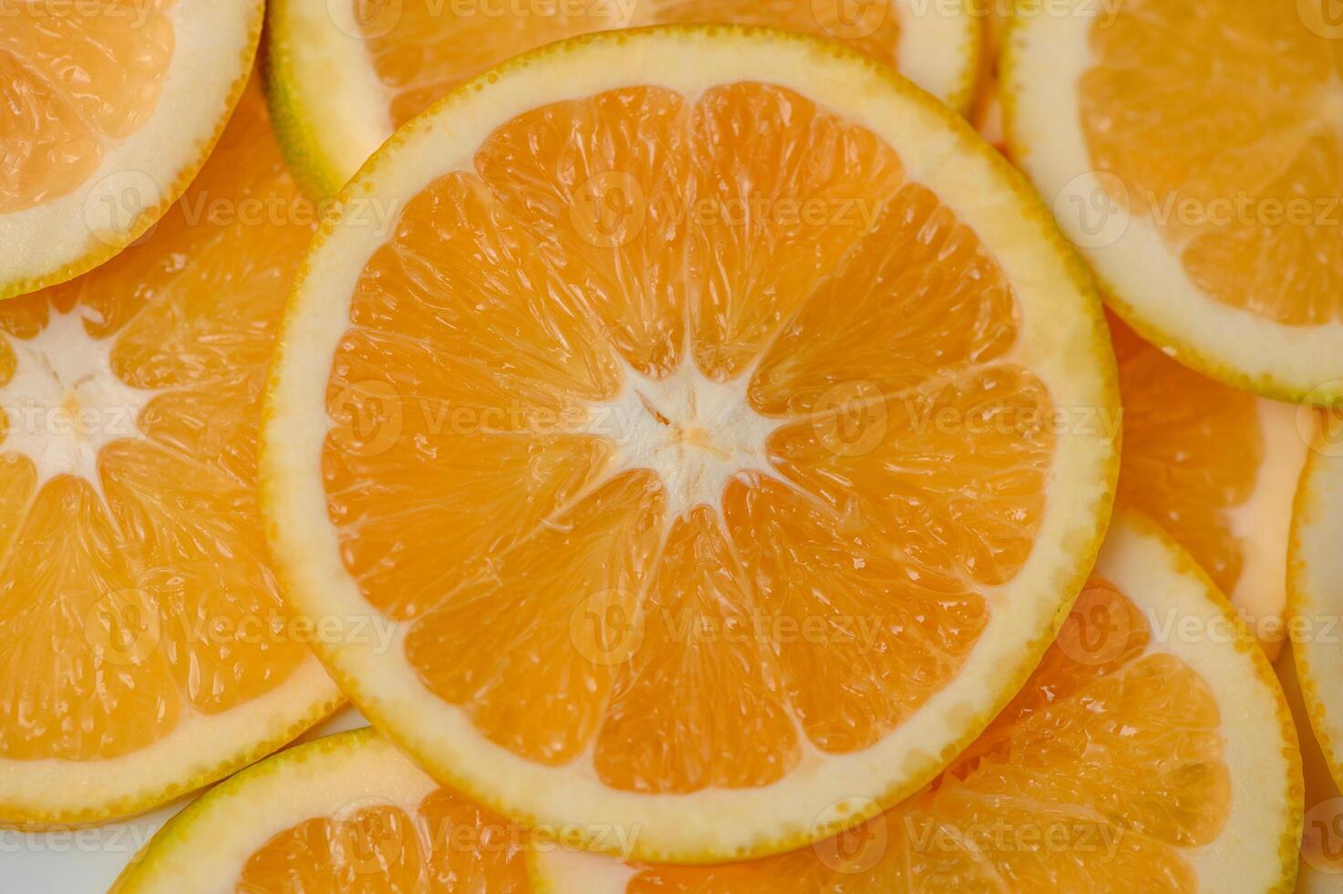 Sliced orange circles, laid on the surface in several layers. Tropical background for design and web photo