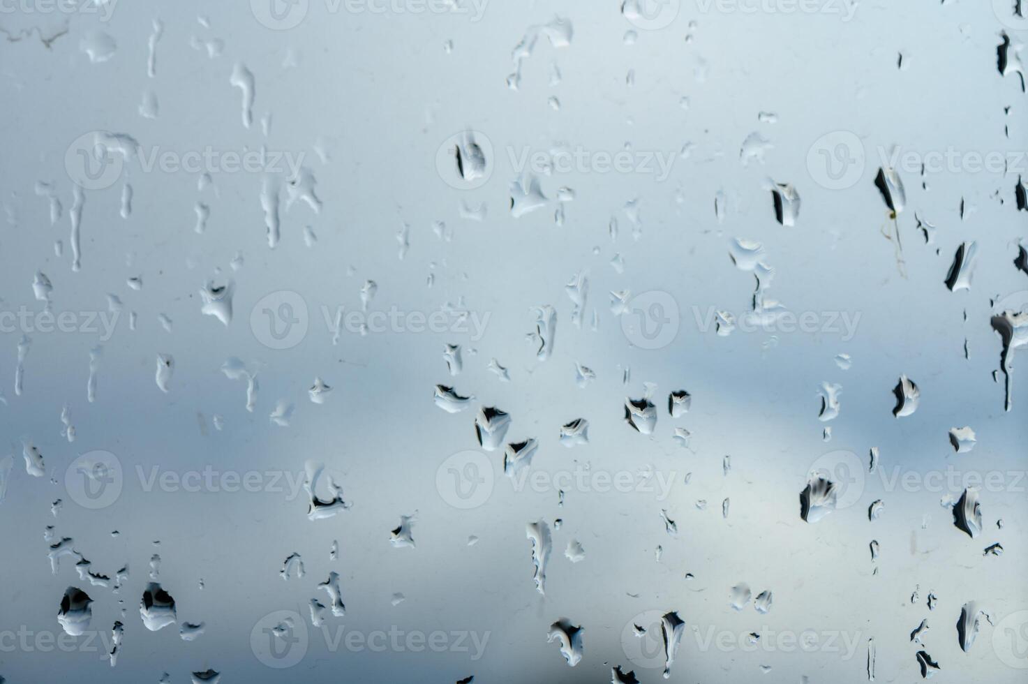 Glass with rain drops against gray background. 2 photo