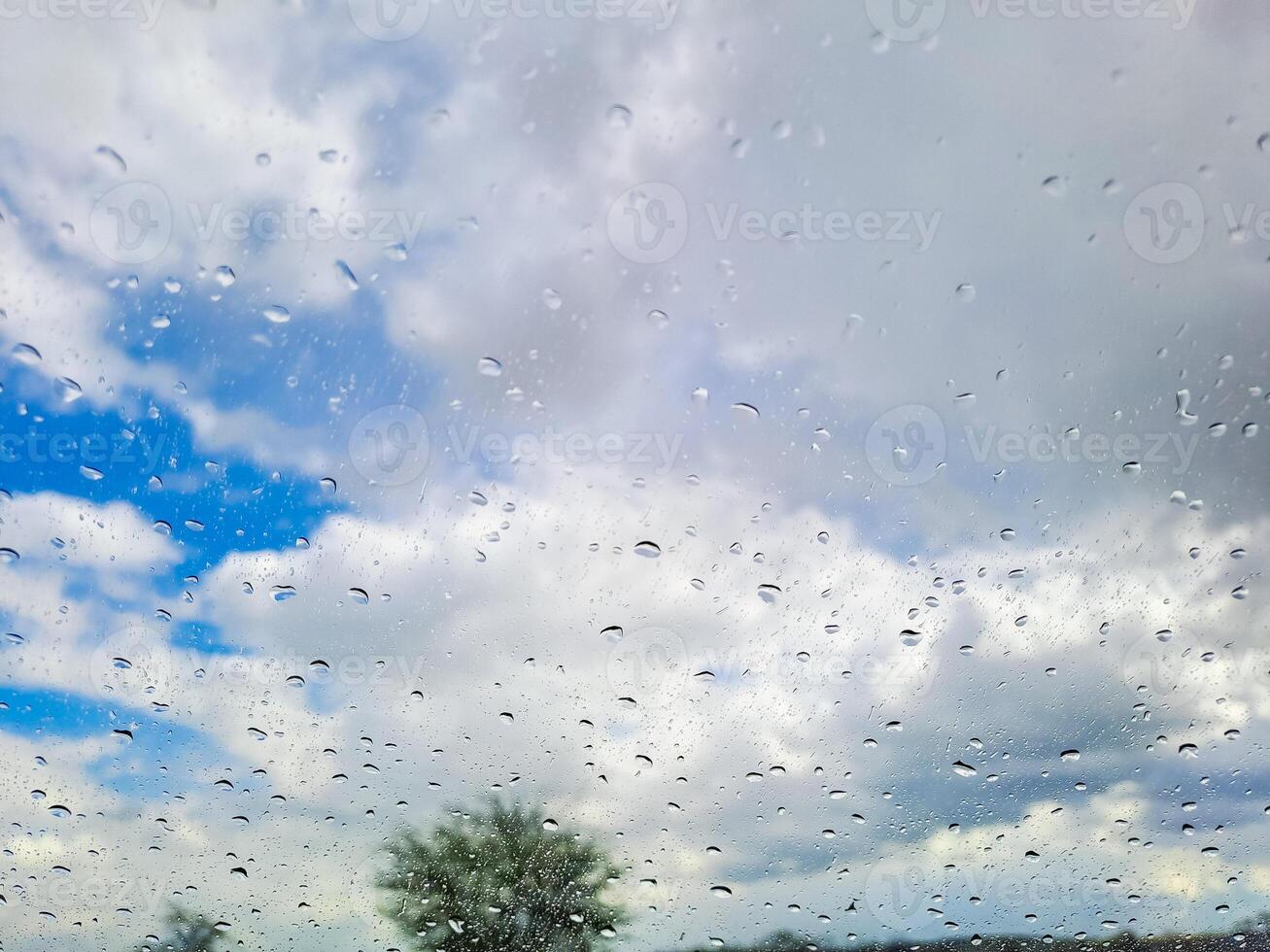 View from wet car window on rainy spring clouds photo