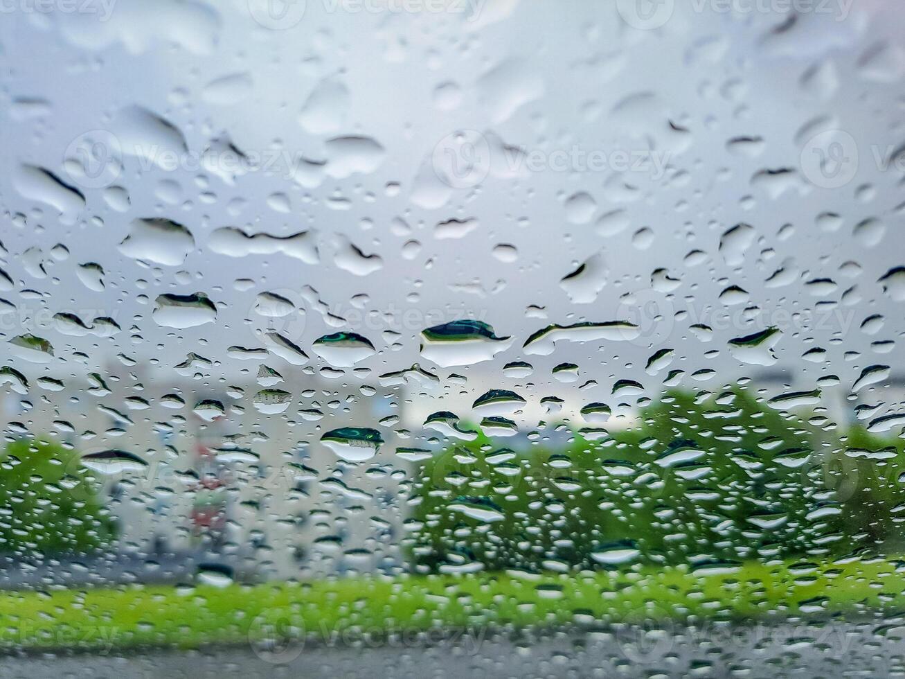 View from wet car window on rainy spring clouds photo