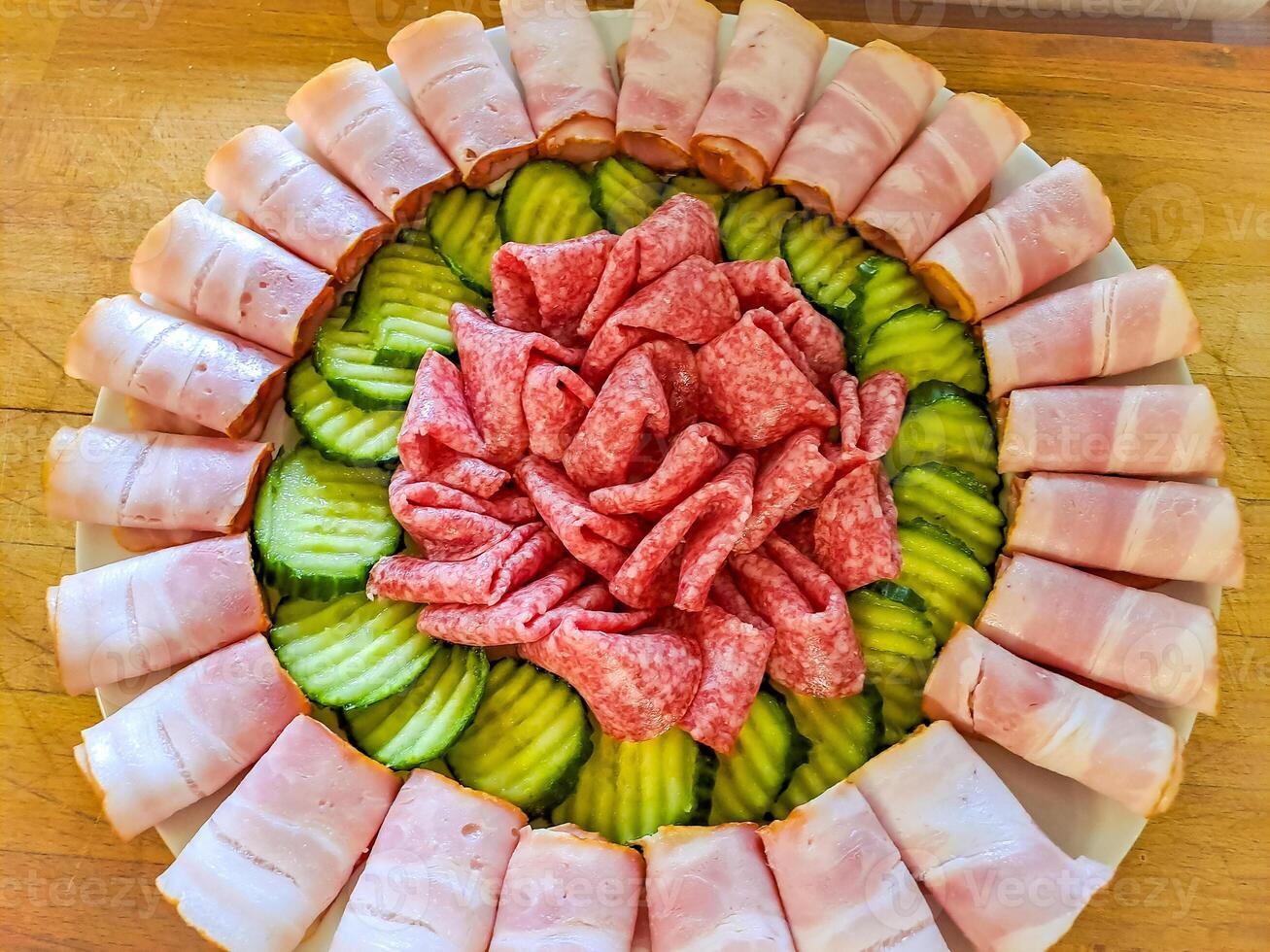 Set of cold cuts for a banquet, meat board with slices of sausage, ham, cucumber photo