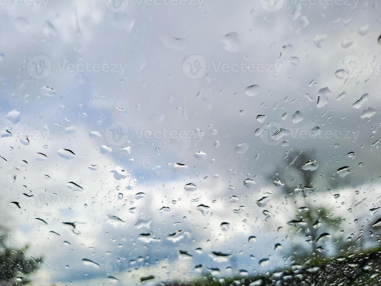 View from wet car window on rainy spring clouds photo