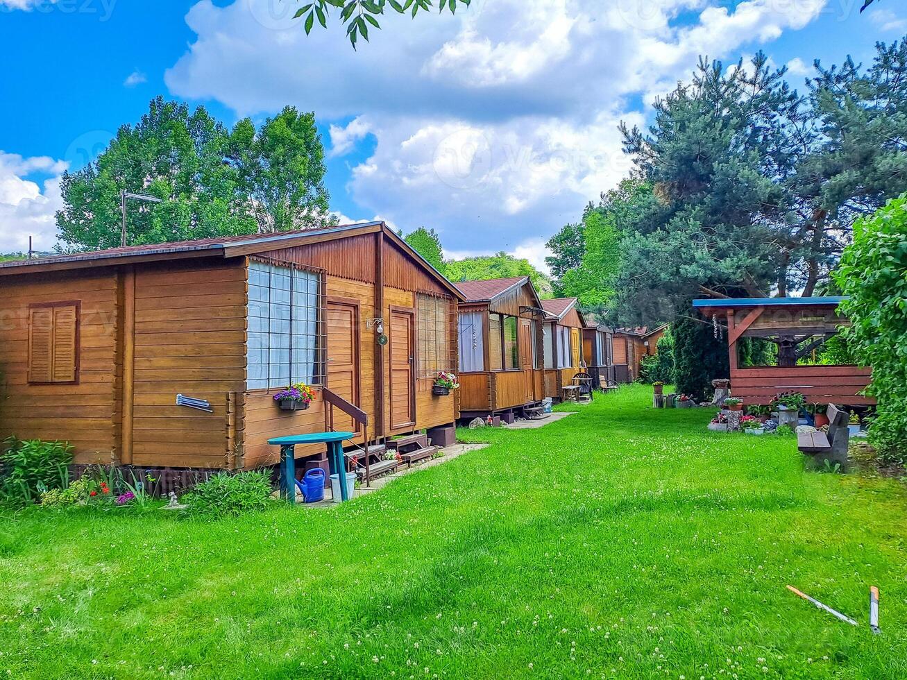 Camping house, row of small wooden huts or houses on green valley. Zadni Treban photo