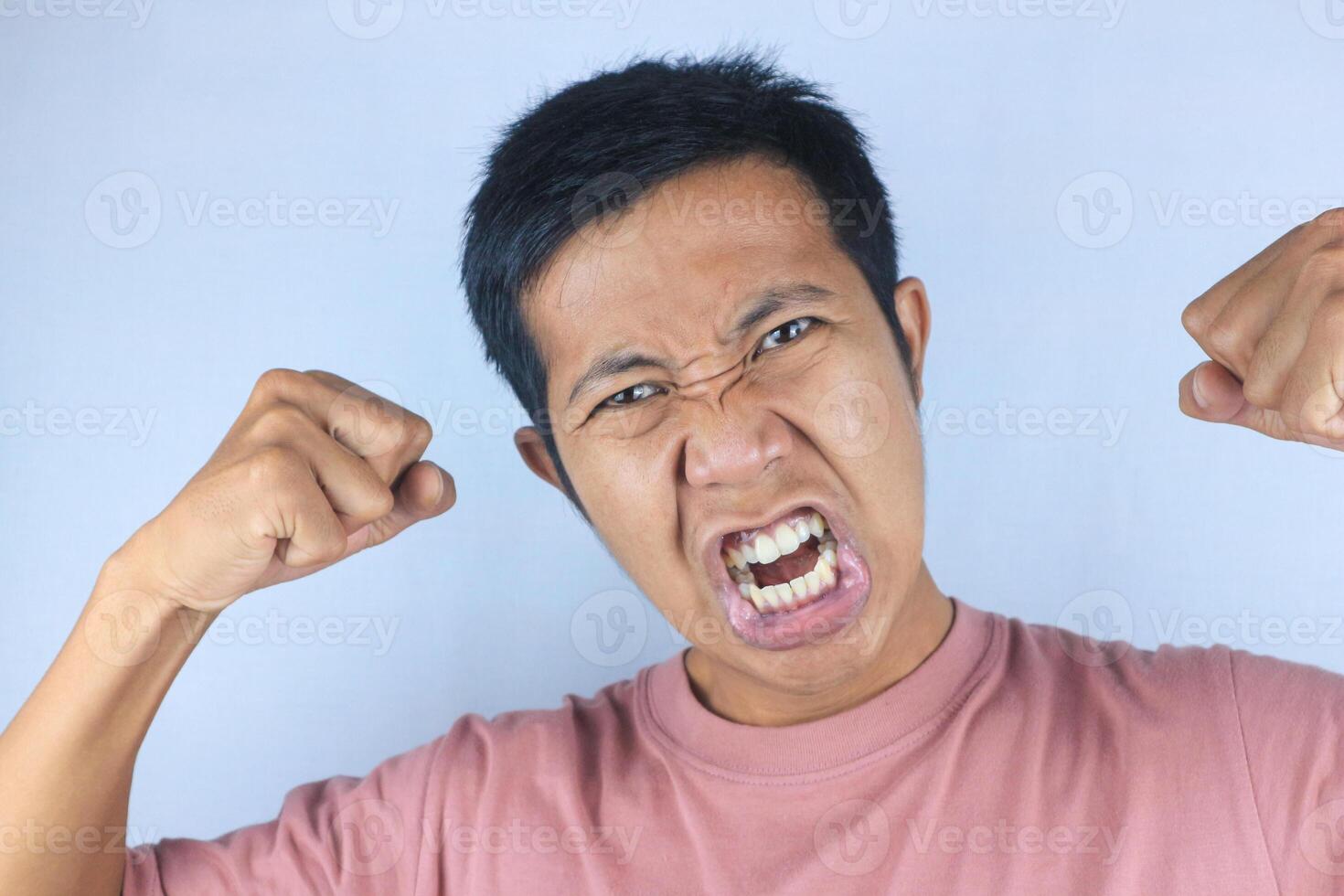 angry facial expression of asian man while making strong hand gesture, isolated on white background photo