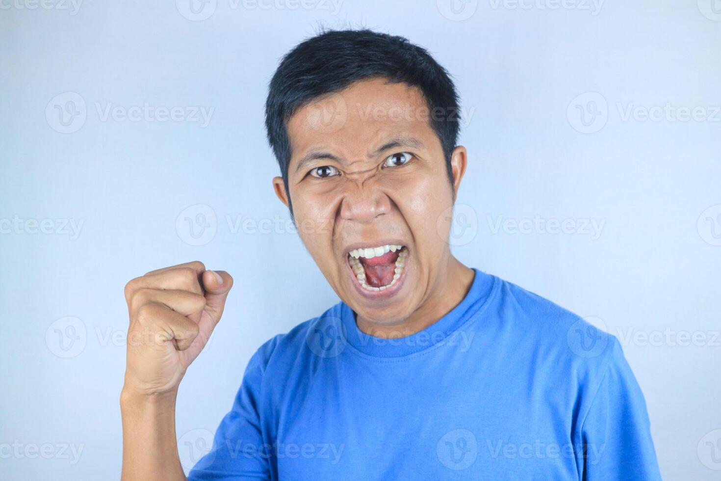 angry facial expression of asian man while making strong hand gesture, isolated on white background photo