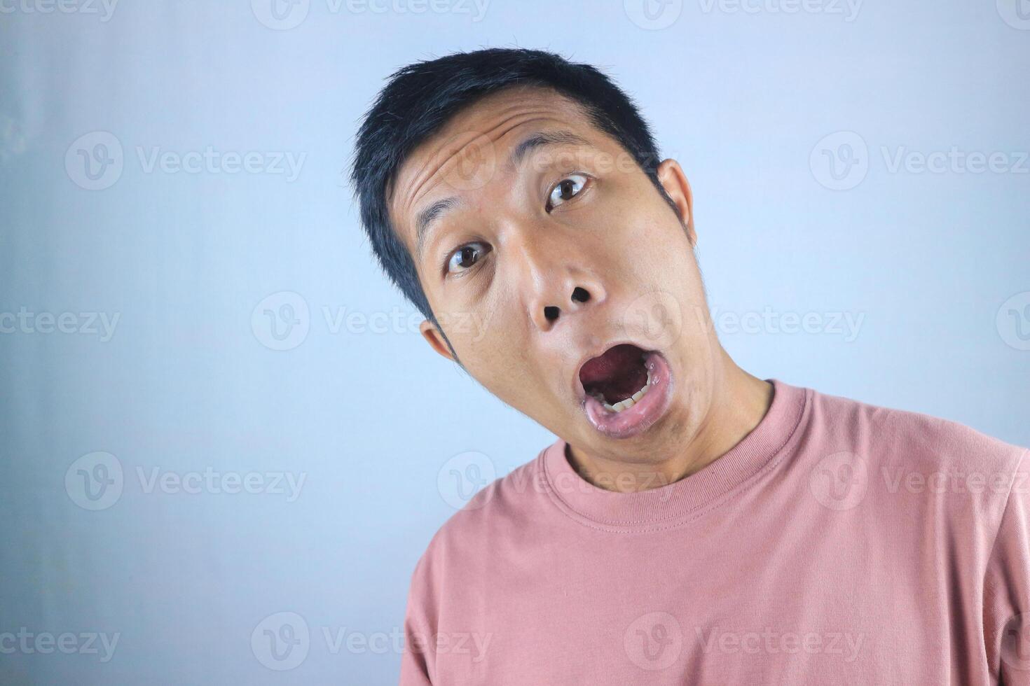 Silly facial expression young asian man looking at camera, isolated on white background photo