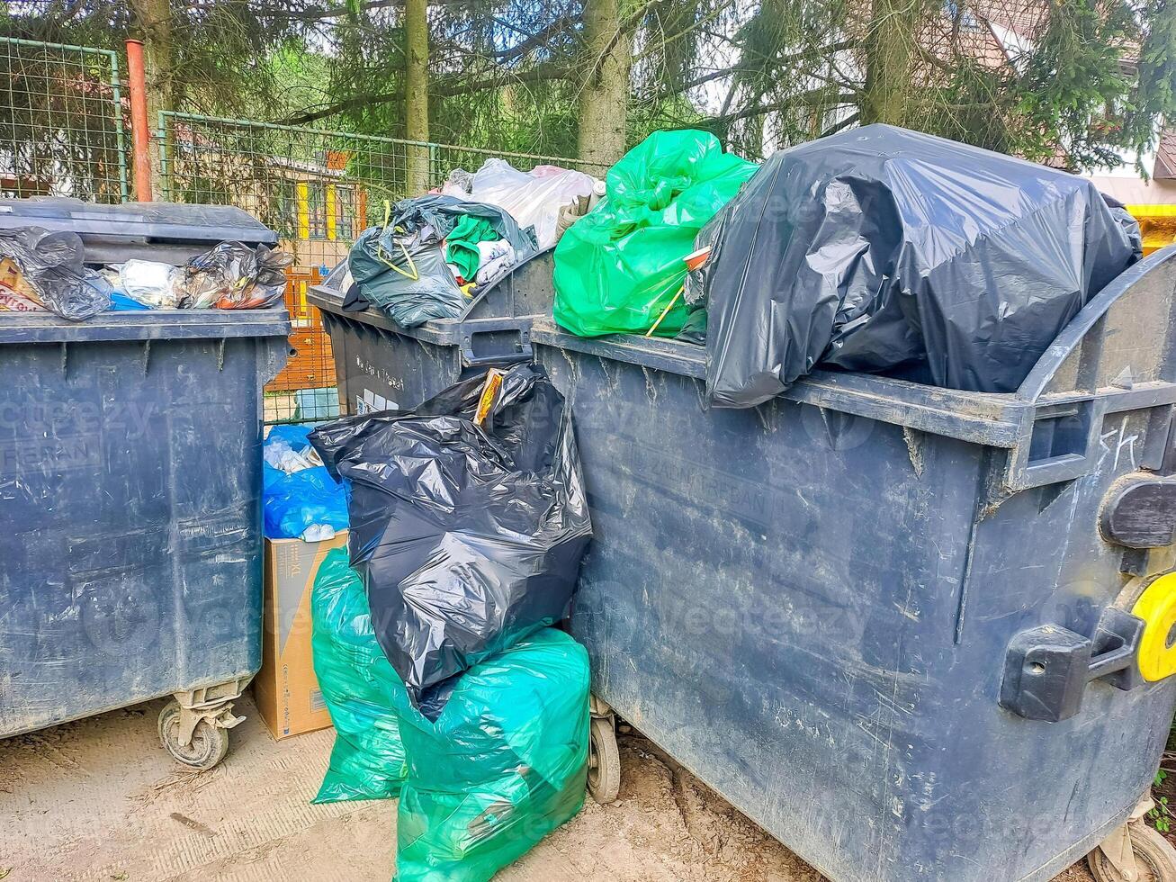 Dumpsters being full with garbage. Trash can overflowing litter pollution photo