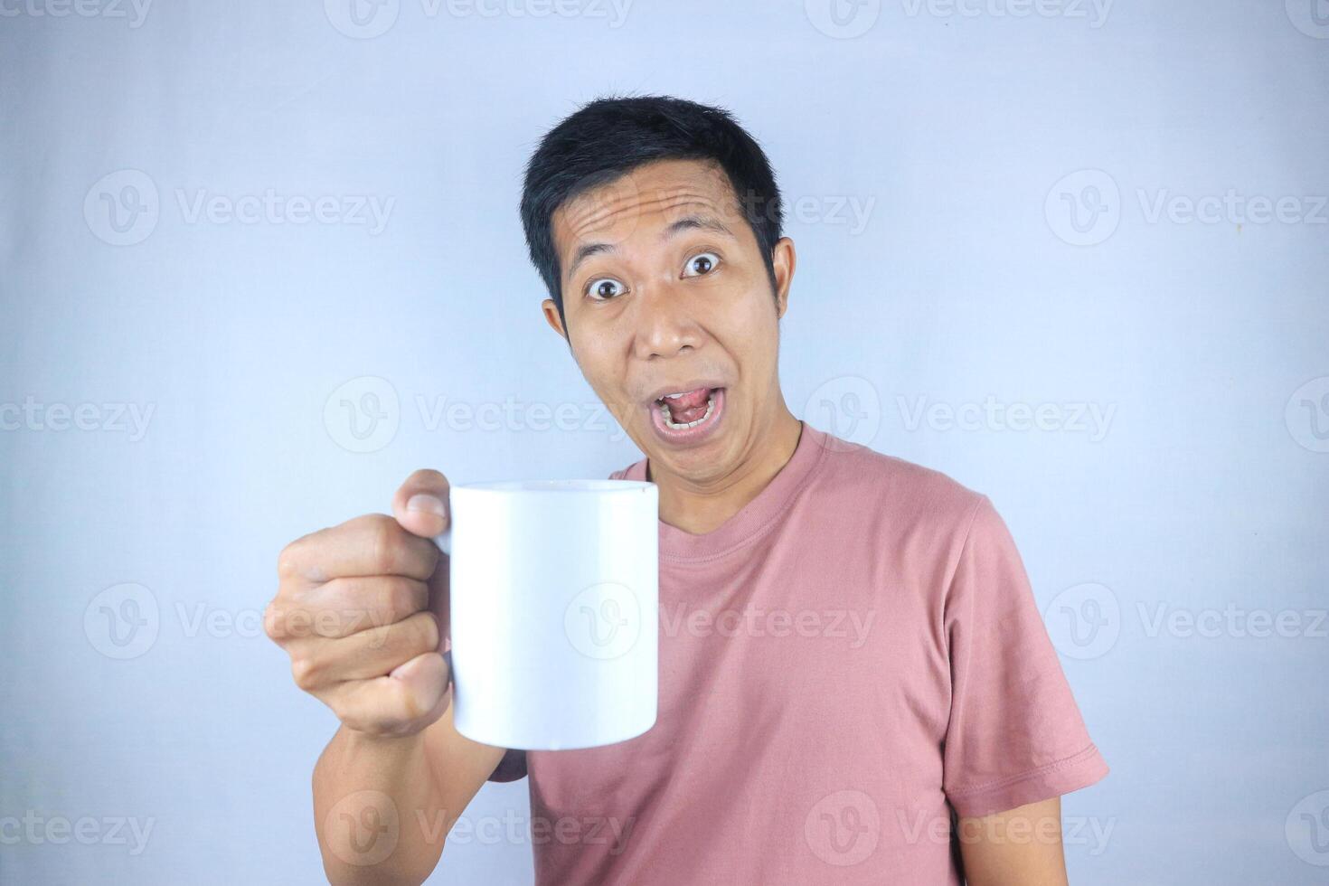 Smiling expression young asian man wearing t-shirt holding coffee cup, isolated on white background photo