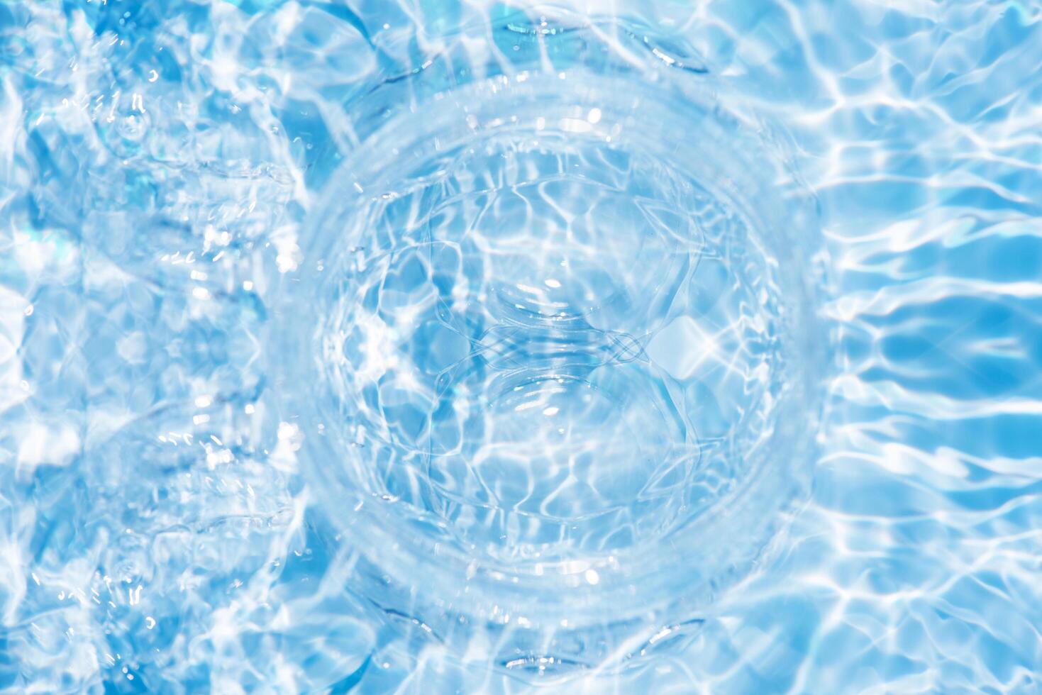 Bluewater waves on the surface ripples blurred. Defocus blurred transparent blue colored clear calm water surface texture with splash and bubbles. Water waves with shining pattern texture background. photo