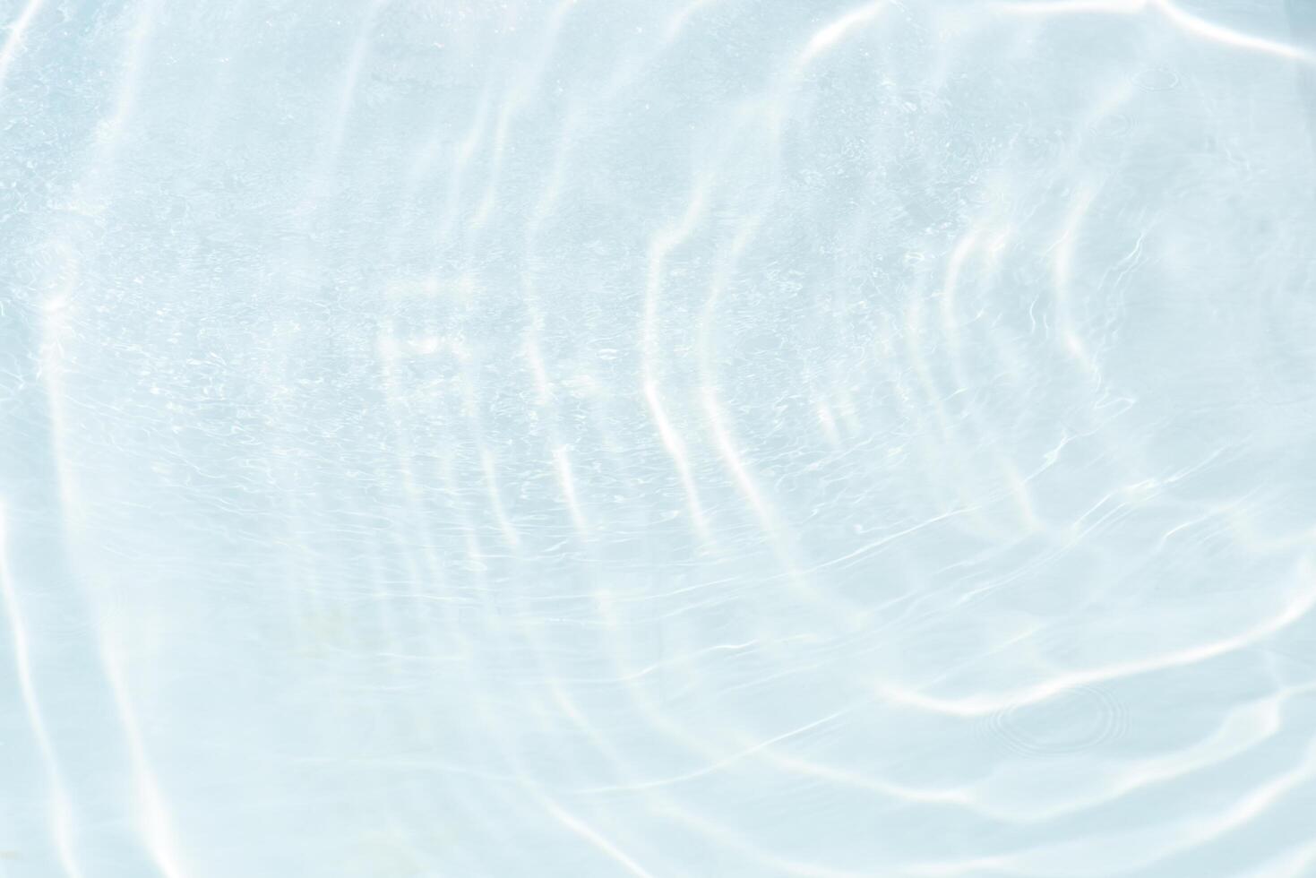 Blue water with ripples on the surface. Defocus blurred transparent blue colored clear calm water surface texture with splashes and bubbles. Water waves with shining pattern texture background. photo