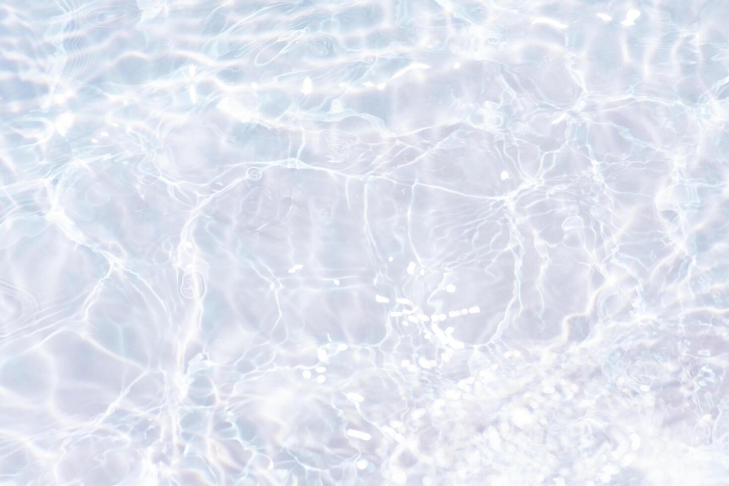Blue water with ripples on the surface. Defocus blurred transparent blue colored clear calm water surface texture with splashes and bubbles. Water waves with shining pattern texture background. photo