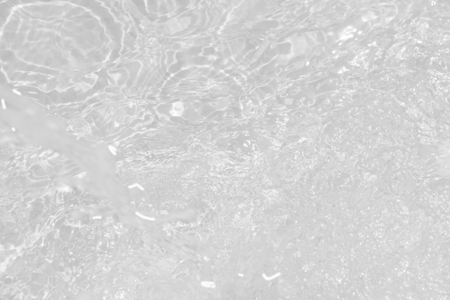 Bluewater waves on the surface ripples blurred. Defocus blurred transparent blue colored clear calm water surface texture with splash and bubbles. Water waves with shining pattern texture background. photo