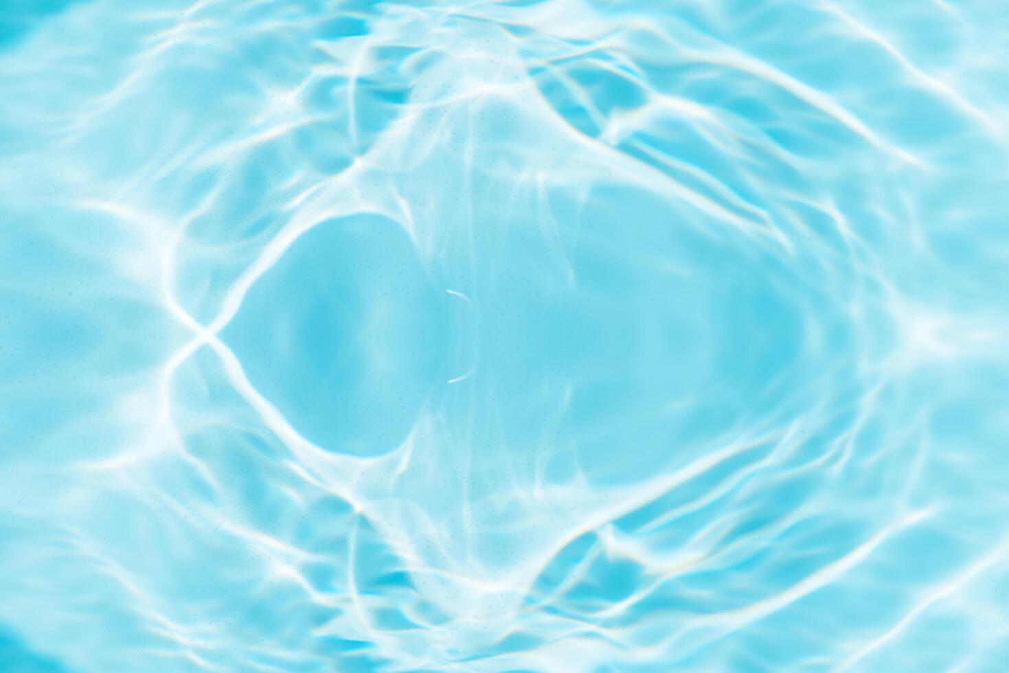 Bluewater waves on the surface ripples blurred. Defocus blurred transparent blue colored clear calm water surface texture with splash and bubbles. Water waves with shining pattern texture background. photo