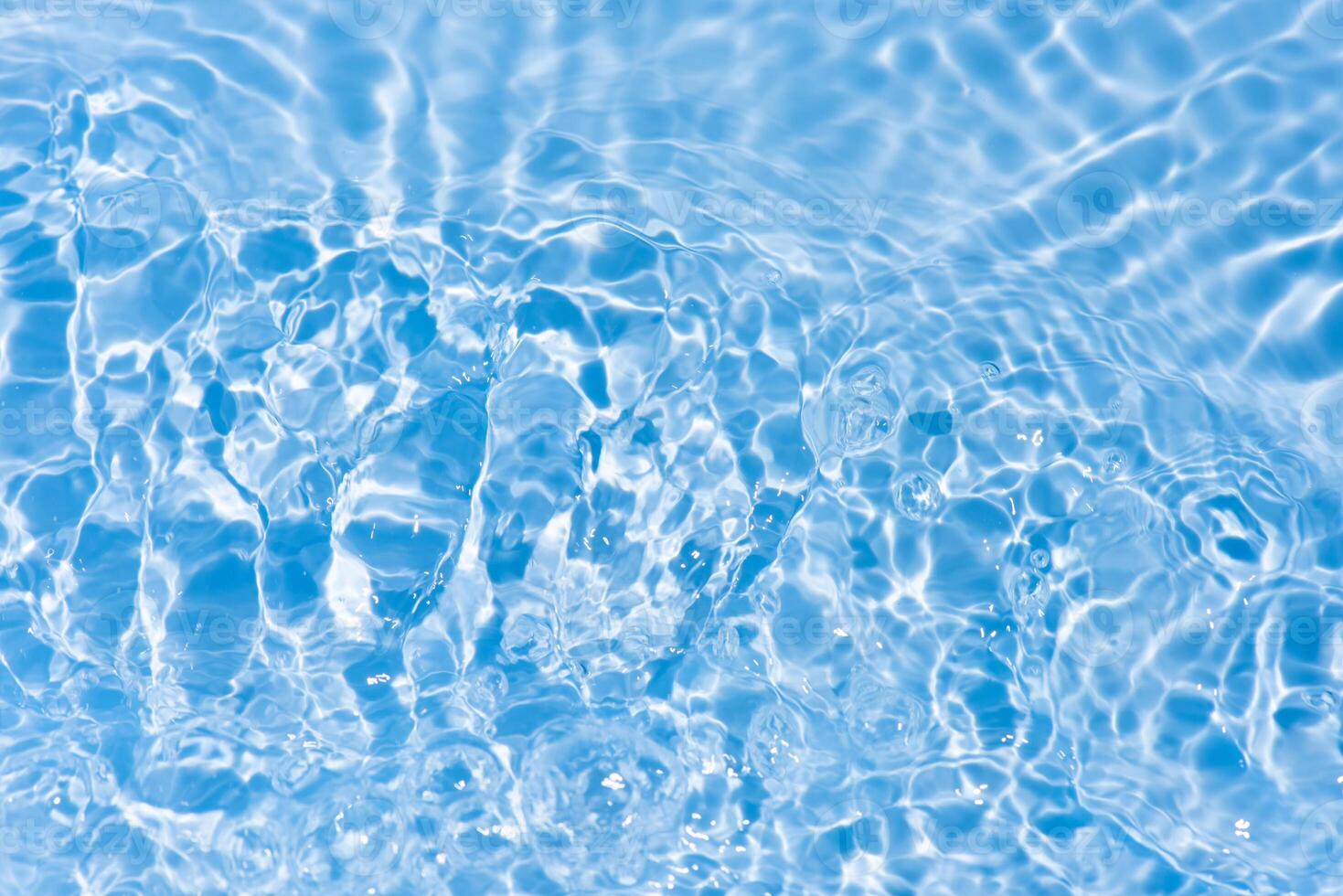 Blue water with ripples on the surface. Defocus blurred transparent blue colored clear calm water surface texture with splashes and bubbles. Water waves with shining pattern texture background. photo