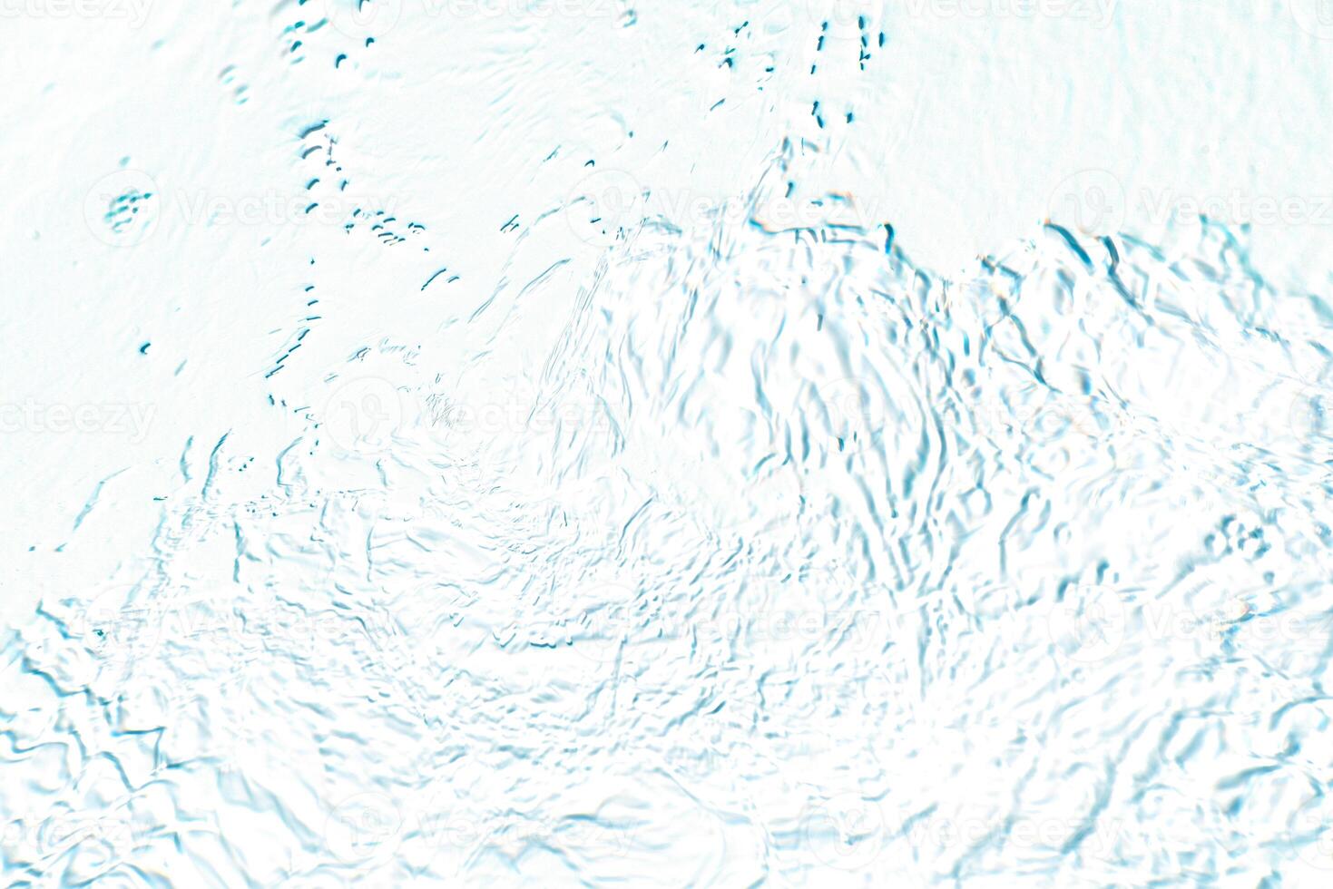 Bluewater waves on the surface ripples blurred. Defocus blurred transparent blue colored clear calm water surface texture with splash and bubbles. Water waves with shining pattern texture background. photo