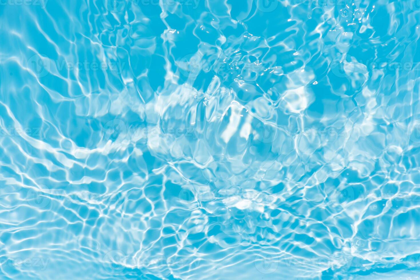 Blue water with ripples on the surface. Defocus blurred transparent blue colored clear calm water surface texture with splashes and bubbles. Water waves with shining pattern texture background. photo