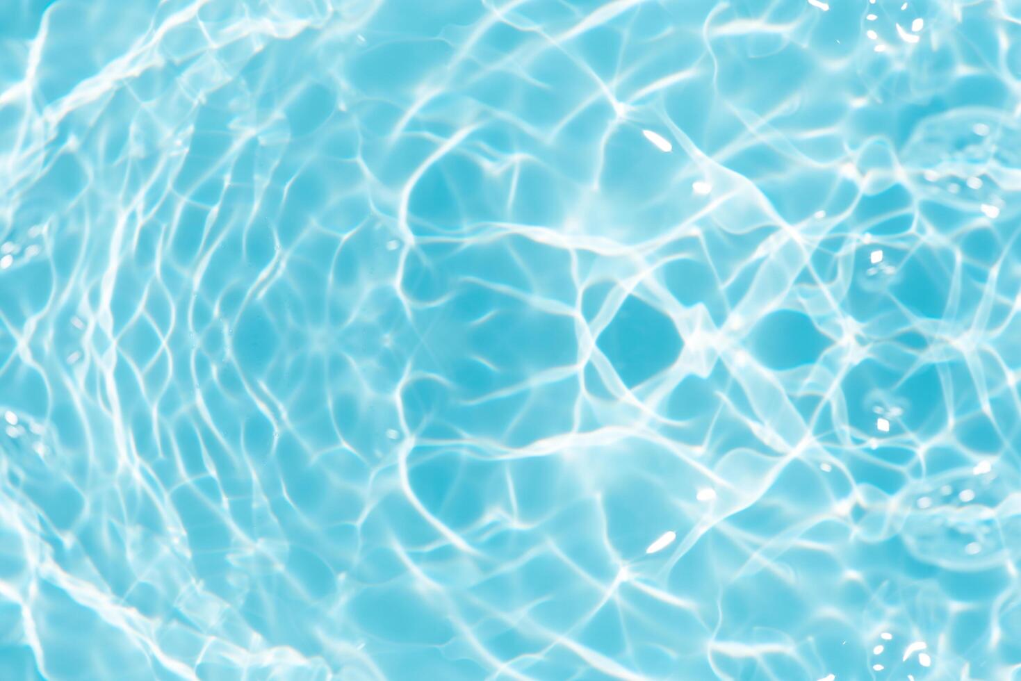Bluewater waves on the surface ripples blurred. Defocus blurred transparent blue colored clear calm water surface texture with splash and bubbles. Water waves with shining pattern texture background. photo