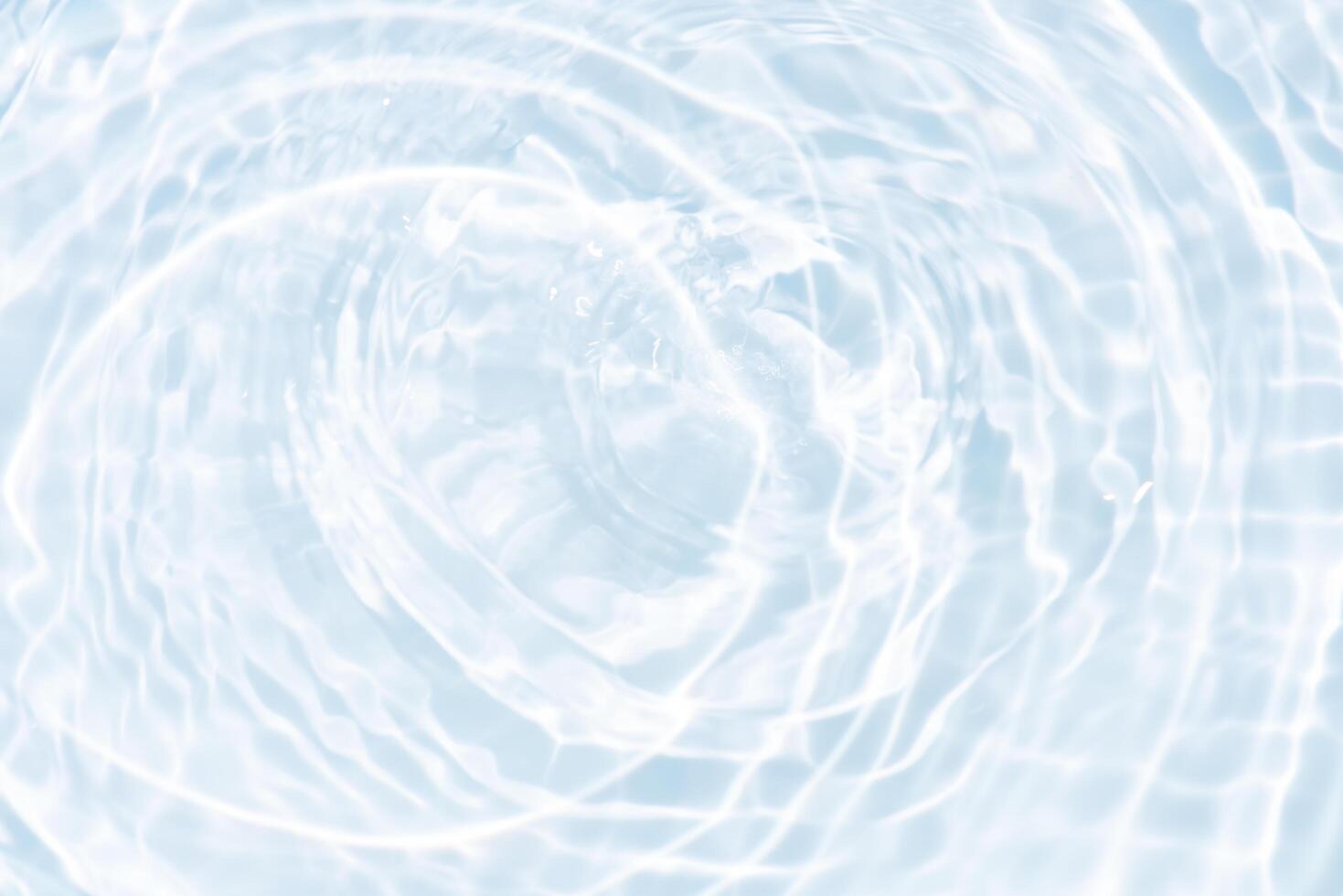 Bluewater waves on the surface ripples blurred. Defocus blurred transparent blue colored clear calm water surface texture with splash and bubbles. Water waves with shining pattern texture background. photo