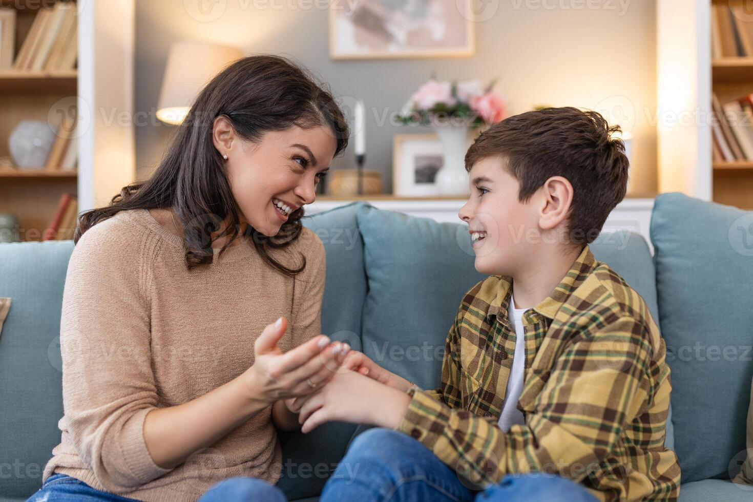 Happy and smiling mother and son resting and spending time together on a holiday. Relax, happiness and calm woman and her child sitting on a sofa and hugging in a room of their family home. photo