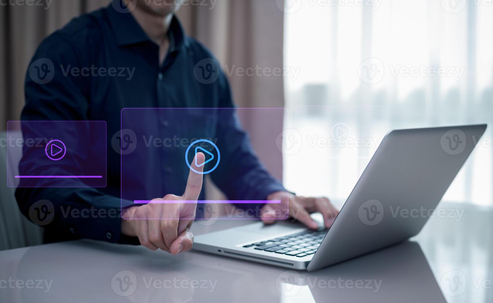 A person is pointing at a screen with playing. The screen is lit up and has a blue background. streaming online, watching on internet education on internet and e-learning concept. photo