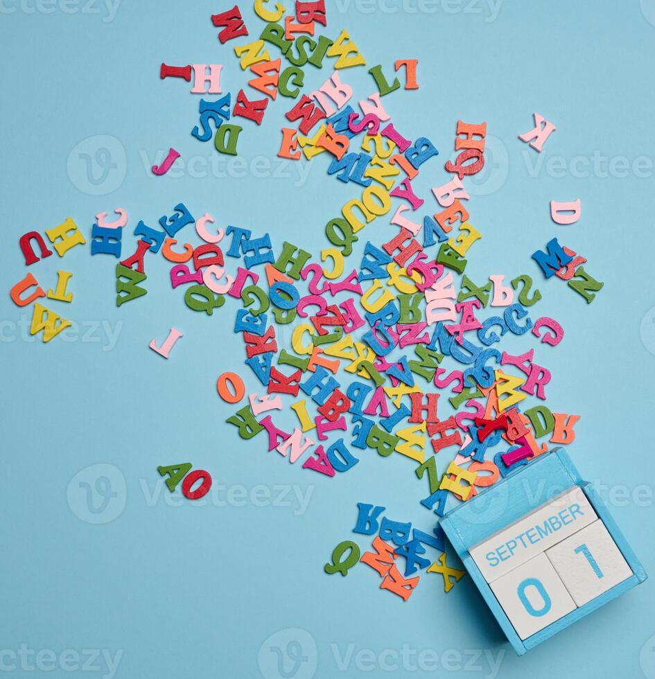 Scattered wooden letters on a yellow background, top view photo