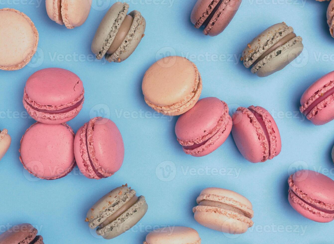 Multicolored macarons on a blue background, top view, dessert photo