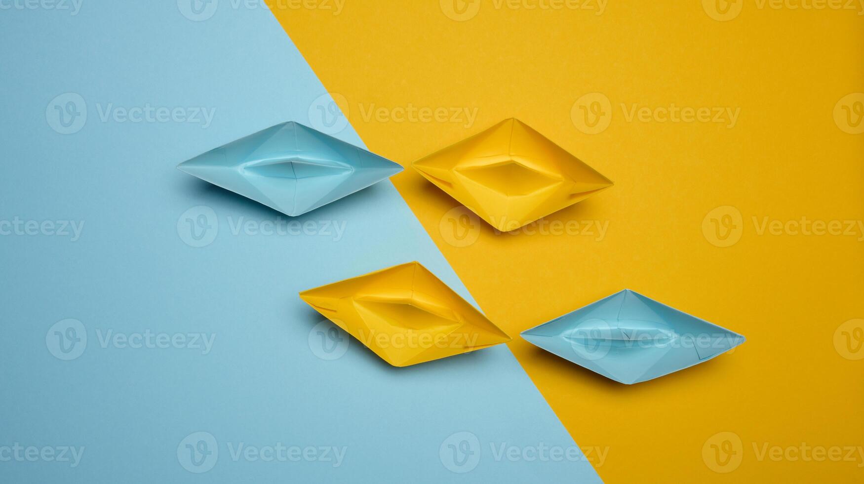 Paper boats on a yellow background, top view, representing the concept of unity and achieving common goals. photo
