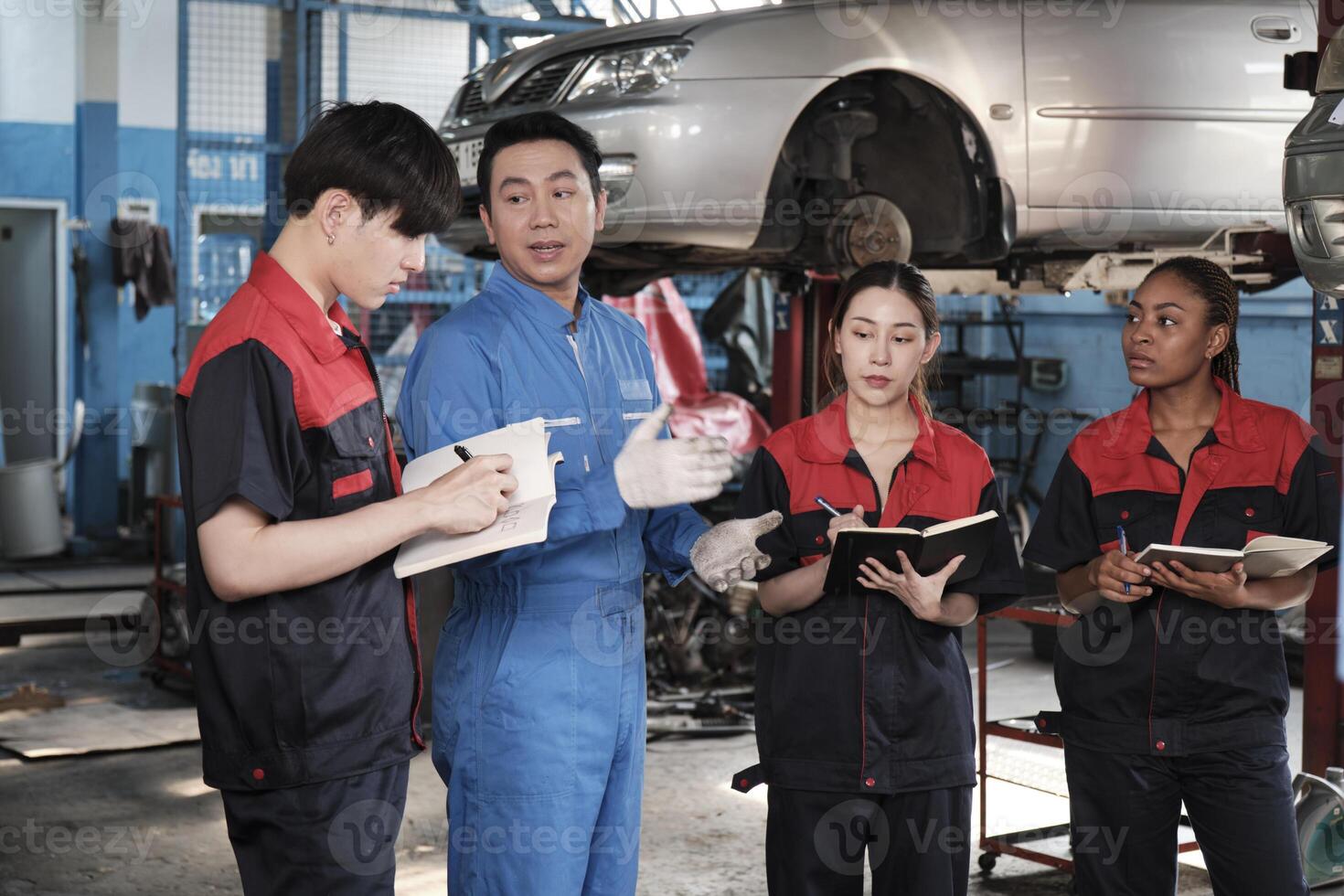 Specialist lecture. Male supervisor engineer describe automotive suspension fixing with mechanic worker staff teams for repair work at car service garage and maintenance jobs in automobile industry. photo