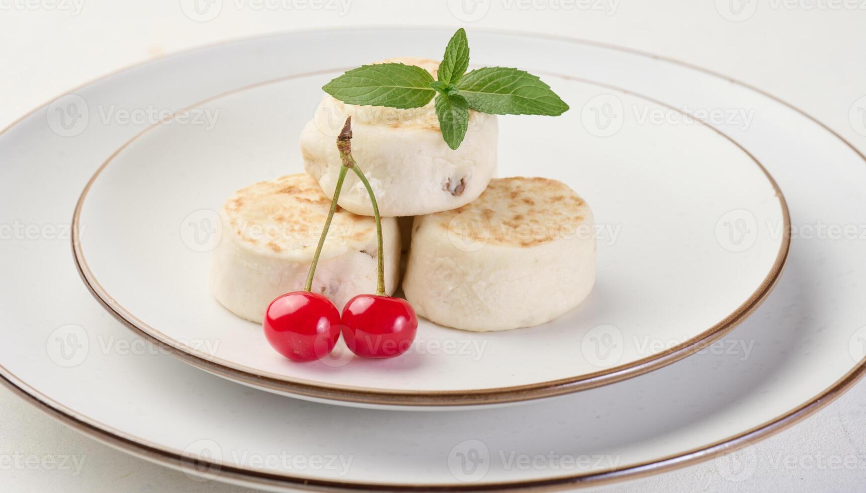 Round small fried cheesecakes on a plate with blueberries. Background white photo