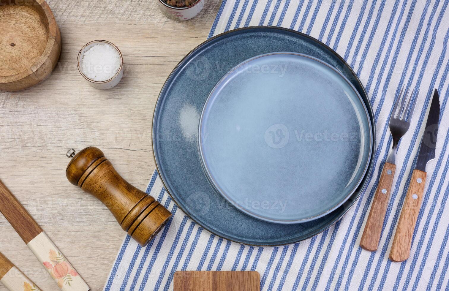 Empty round ceramic plate on the table with spices, top view photo