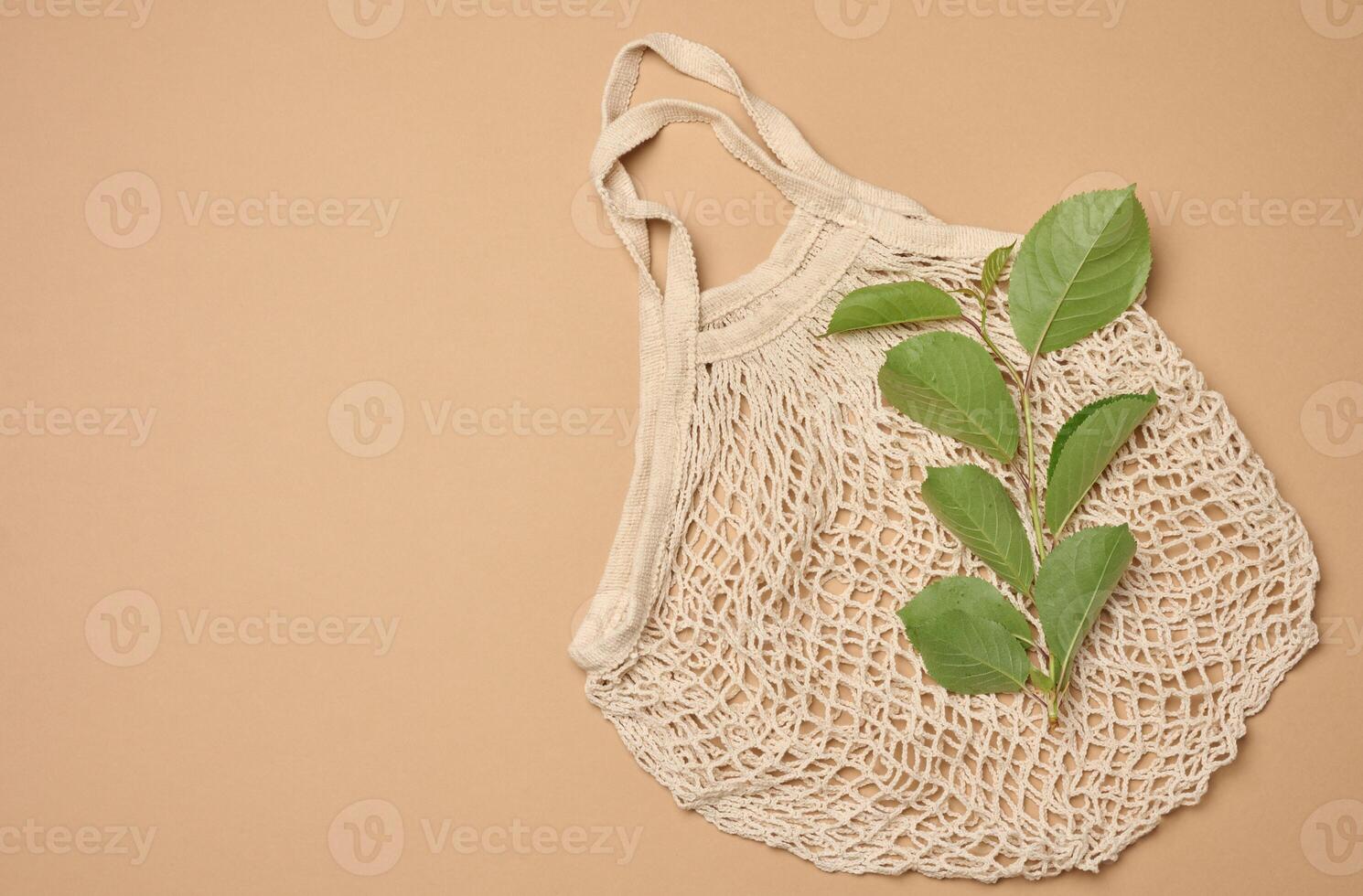 Textile grocery bag on brown background, top view photo