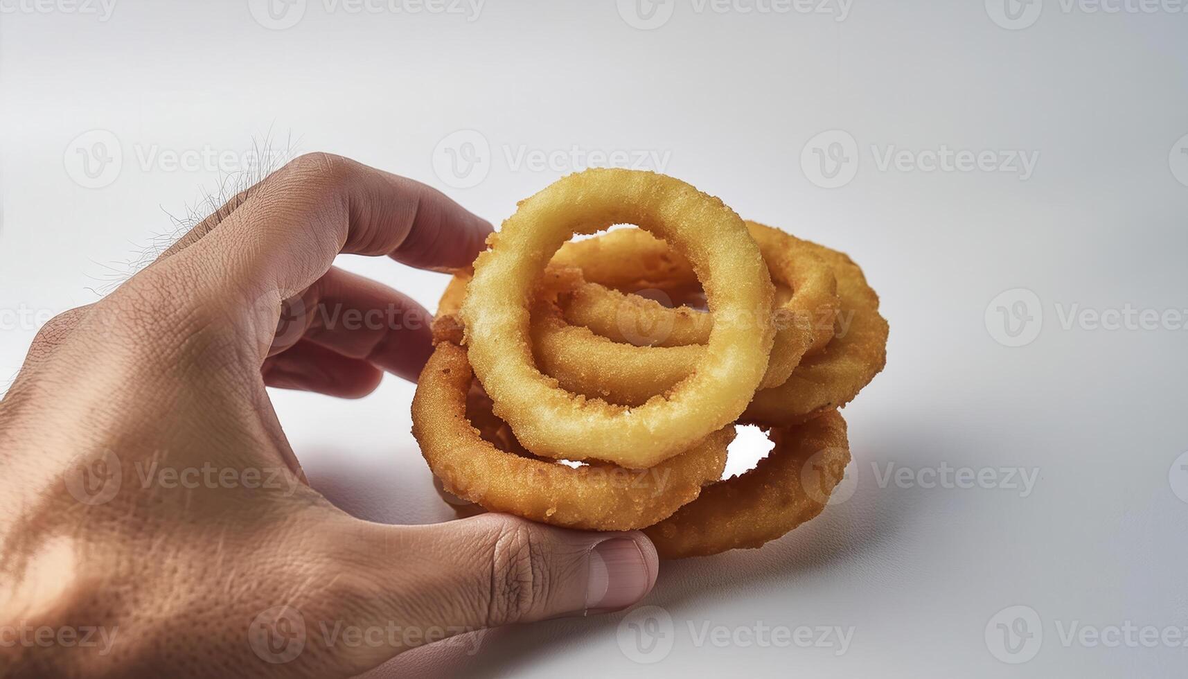Hand holding a stack of freshly fried golden onion rings against a clean white background. Perfect snack or appetizer for any occasion. photo