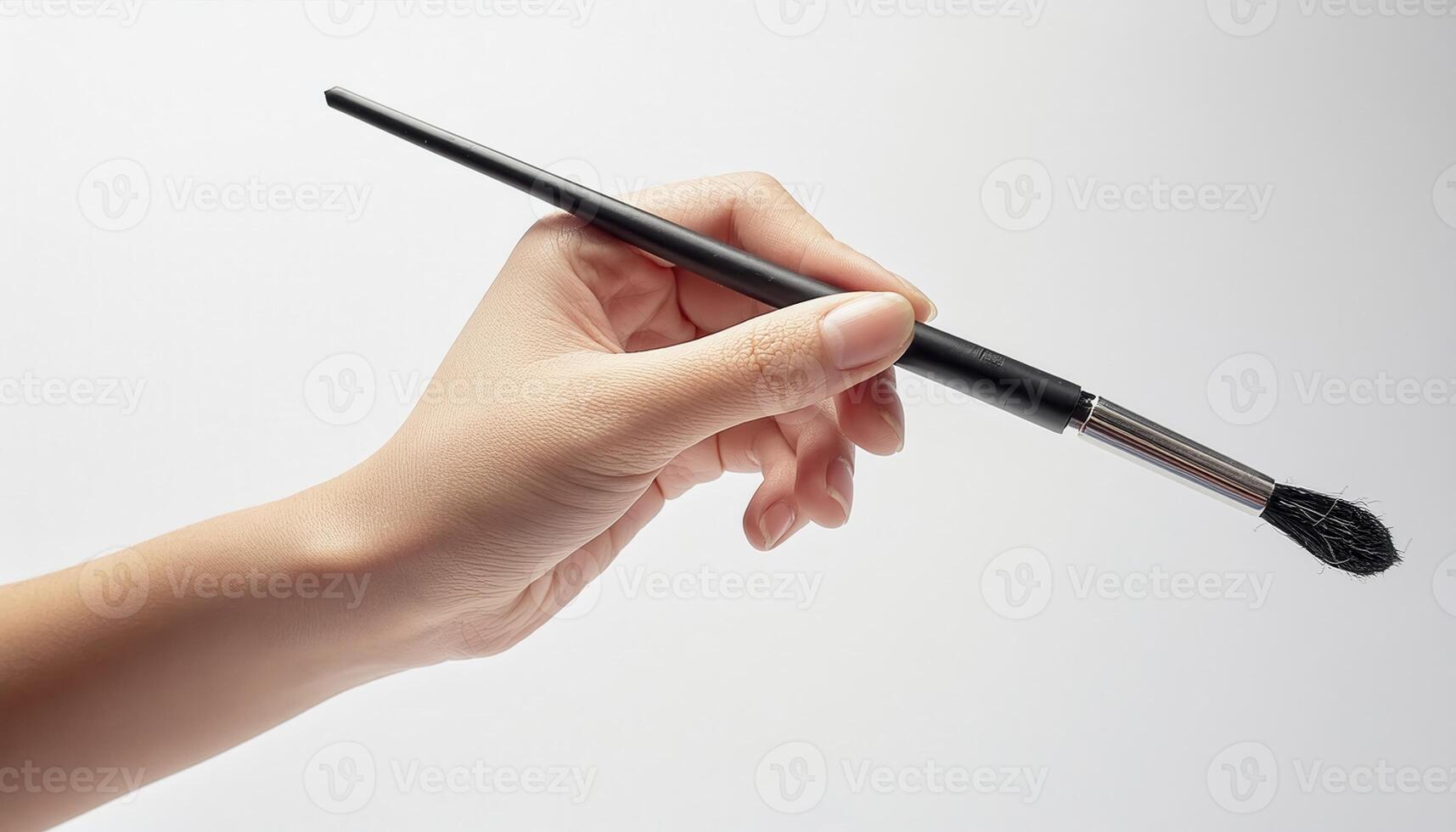 Close-up of a hand holding a paintbrush against a white background. Perfect for art, painting, and creativity concepts. photo