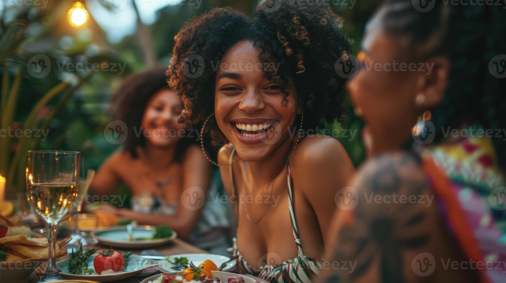 Friends enjoying outdoor dinner together, smiling and laughing around a beautifully set table with food and drinks. photo