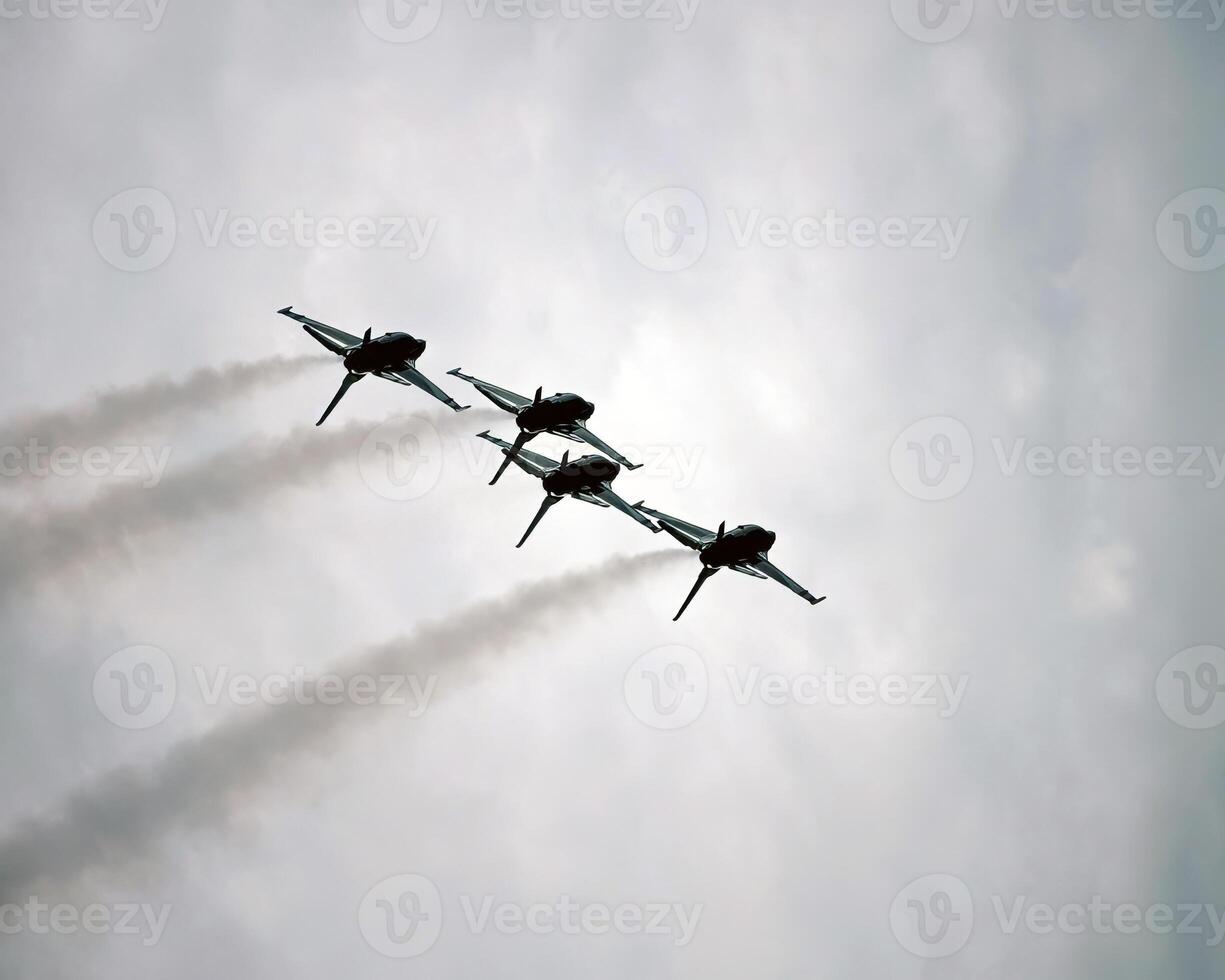 Airshow of military jet fighters. Group of military airplanes performs maneuvers with a smoke trace. Aviation background photo