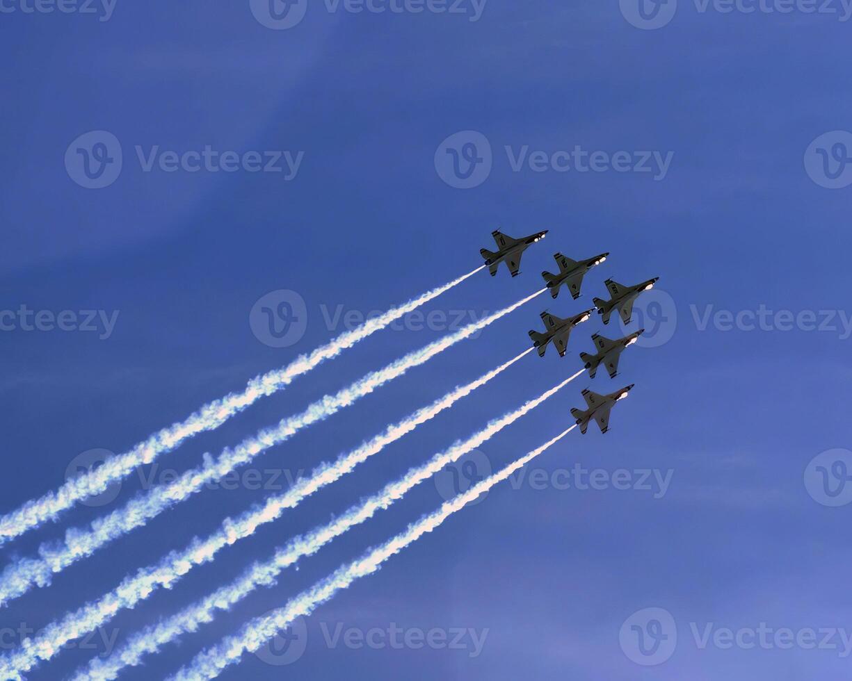 Airshow of military jet fighters. Group of military airplanes performs maneuvers with a smoke trace. Aviation background photo