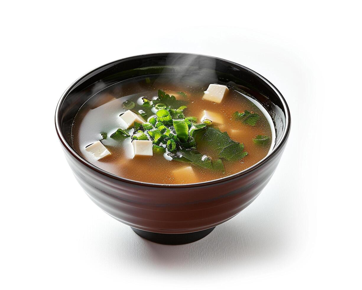 a bowl of soup with tofu and herbs in it photo